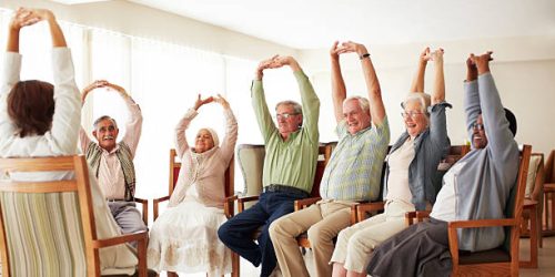 Daily stretching exercise routine for a group of cheerful elderly people at an old age home
